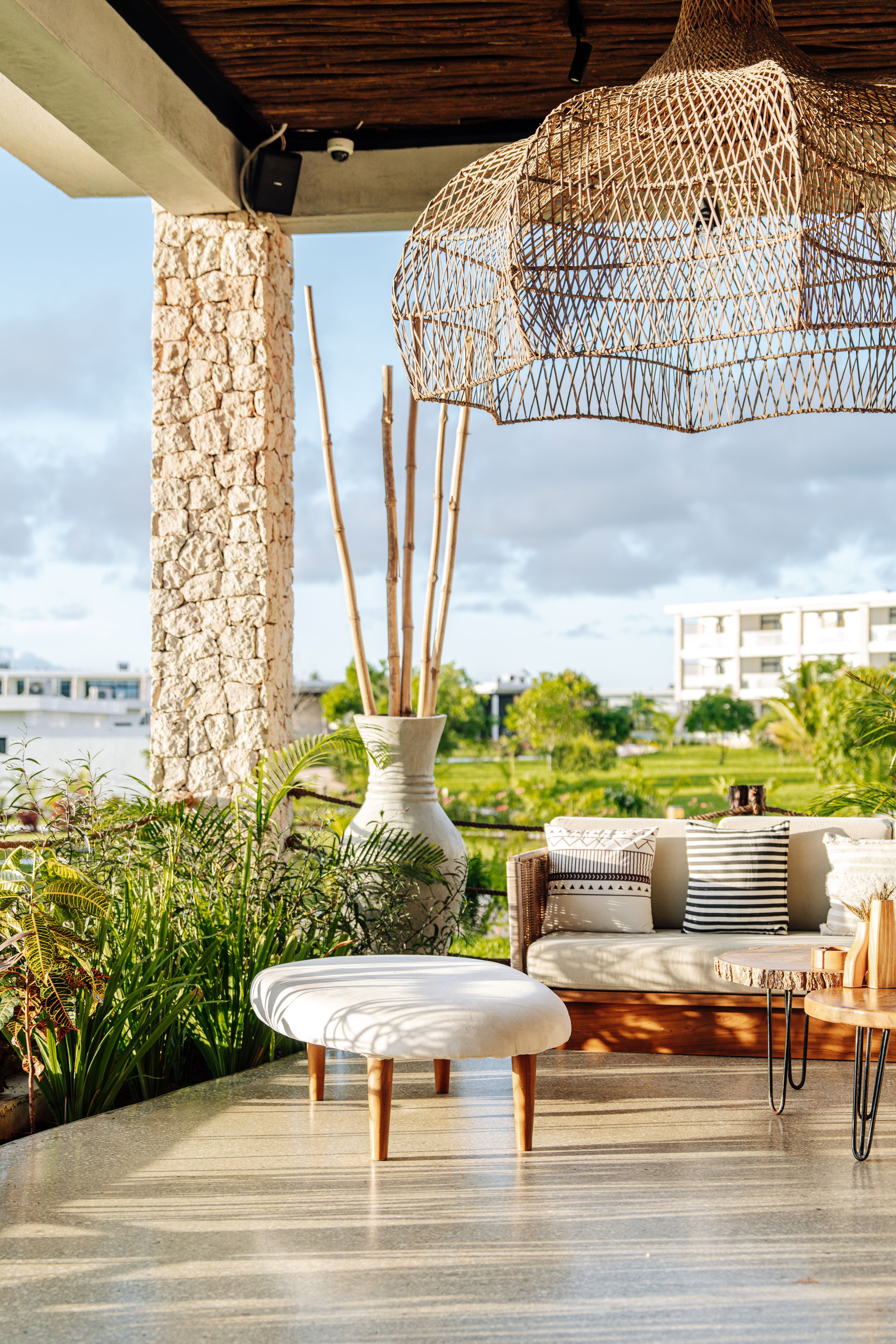 sunlit apartment terrace with wicker and stone